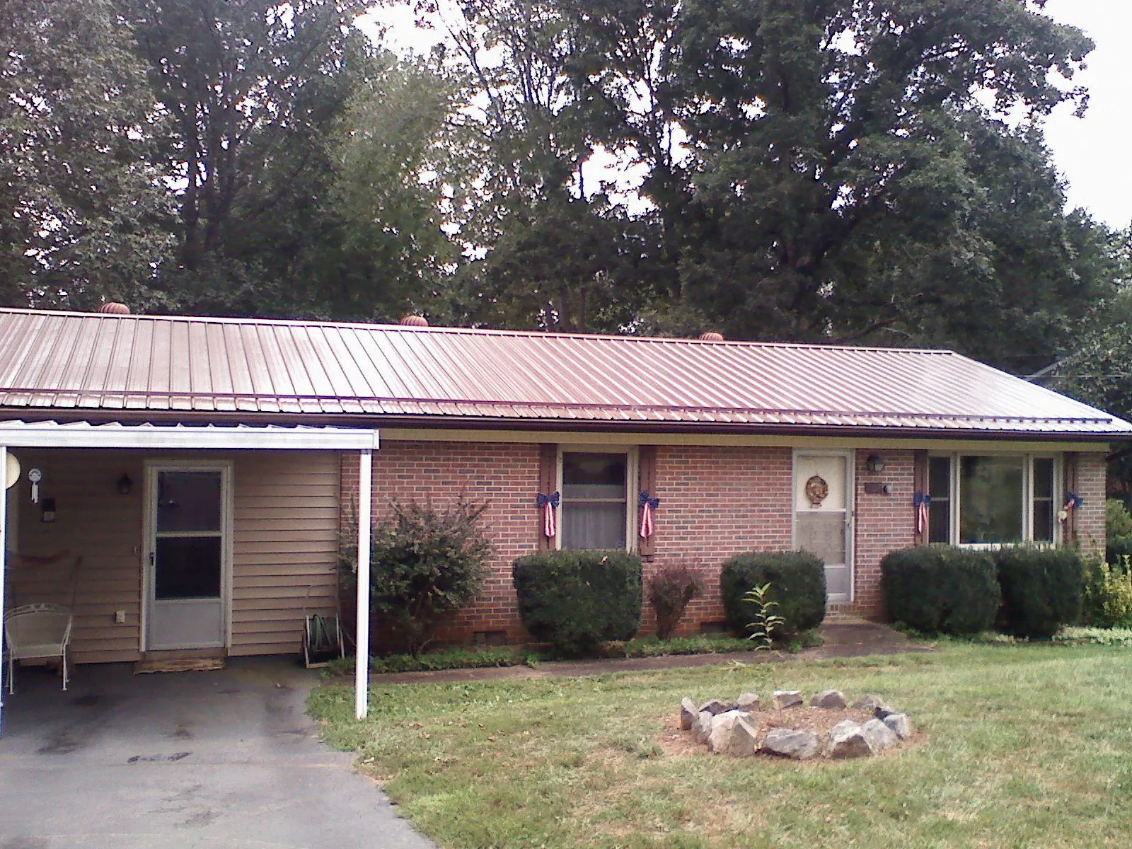 Bronze metal roof and carport on a brick ranch home — Roof Repair work by our crew in Minden